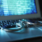 Handcuffs on laptop keyboard, closeup